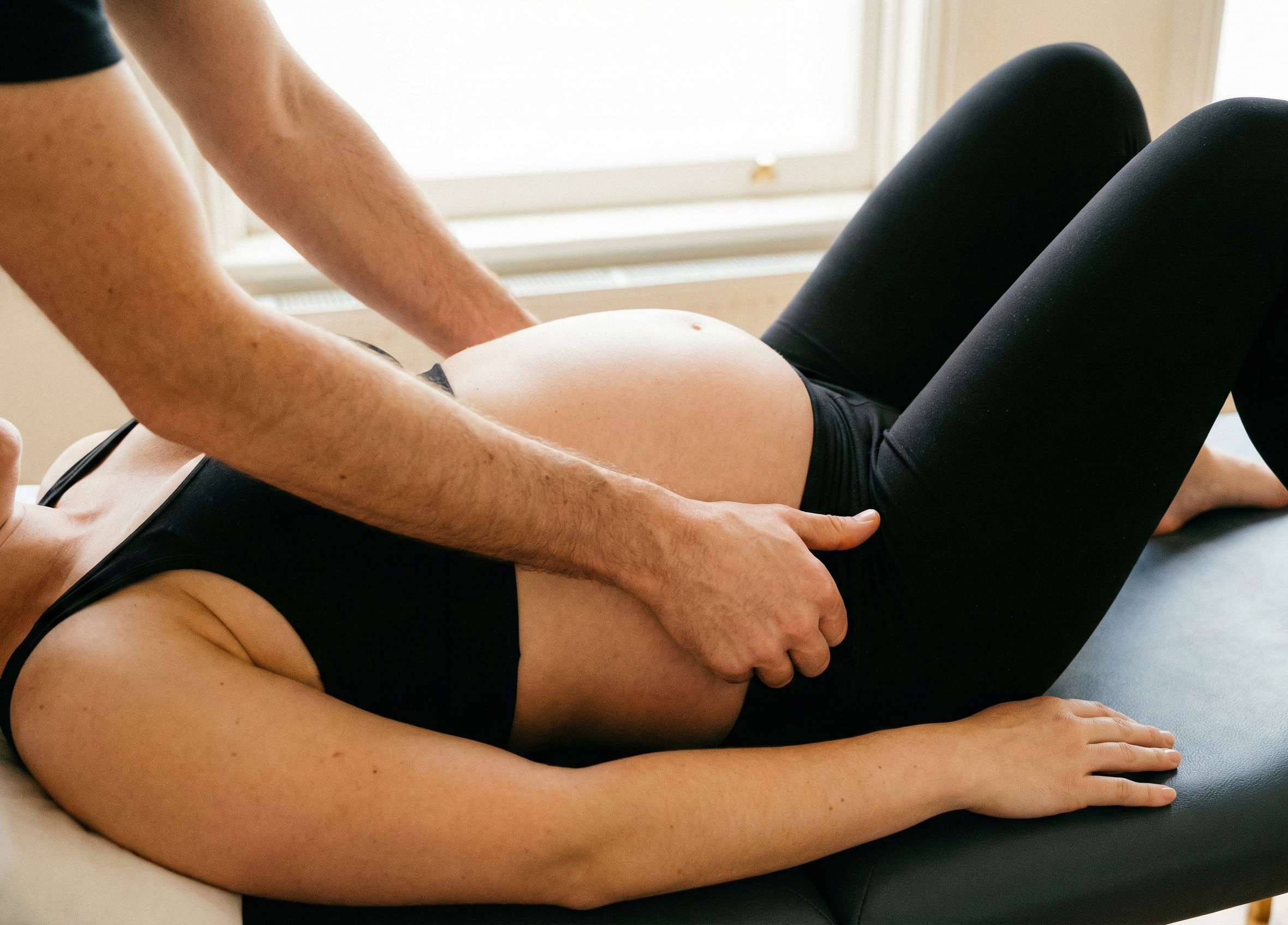 ostéopathe de talant réalisant une technique douce sur une femme enceinte